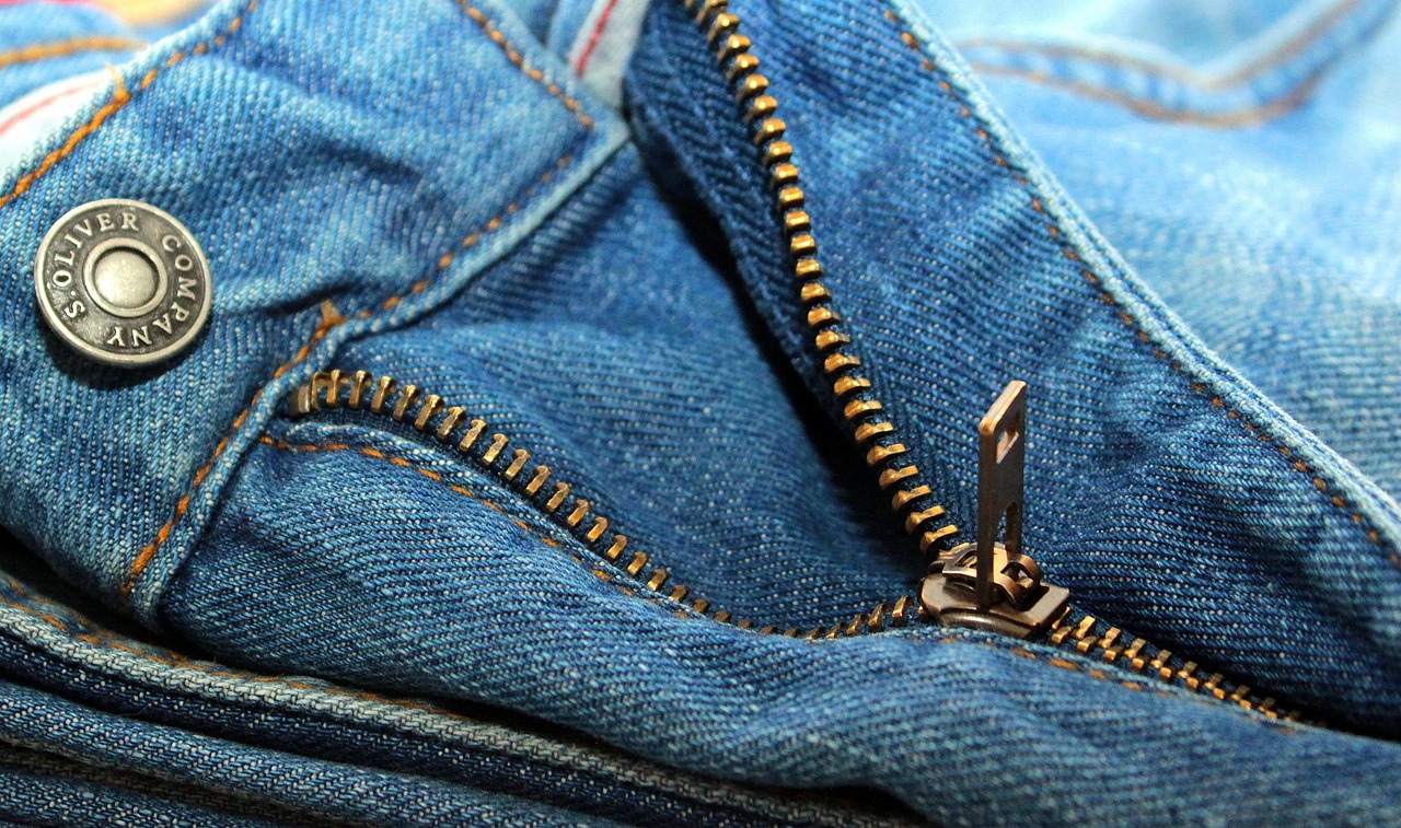 a close up of a zipper on a pair of jeans, a stock photo, by Niko Henrichon, pexels, happening, golden details!, realistic footage, viewed from above, highly_detailded