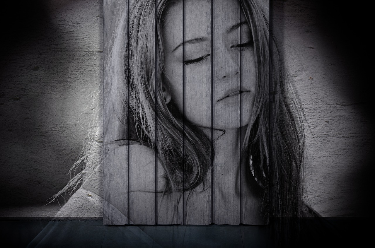 a black and white photo of a woman behind bars, a charcoal drawing, inspired by Kurt Roesch, trending on pixabay, art photography, on wood, photo of a beautiful woman, street art:2, serene emotion