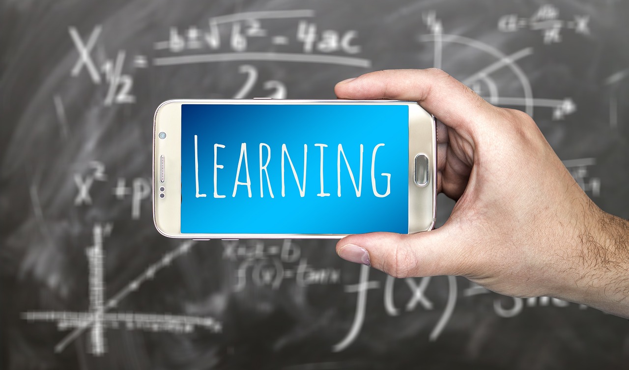 a person holding a smart phone in front of a chalkboard, a picture, learning, closeup photo, deep learning, saying