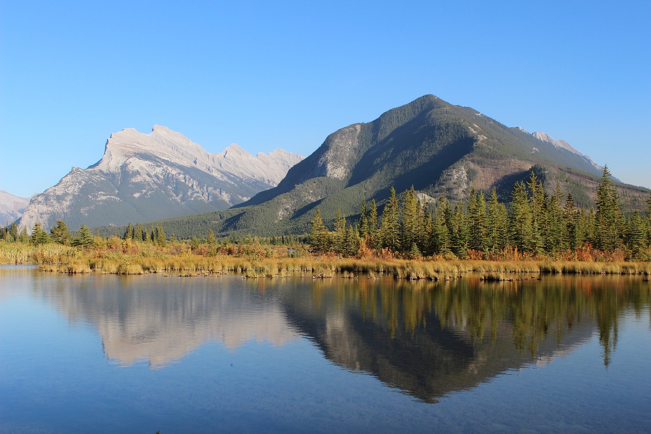 a body of water with mountains in the background, a picture, by Brigette Barrager, pixabay, banff national park, beginning of autumn, reflection, wikimedia commons