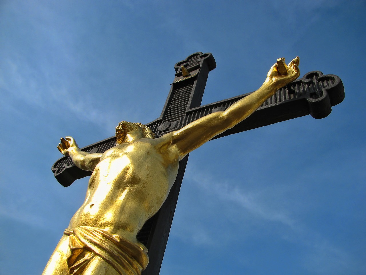 a gold statue of jesus on a cross, a statue, by Andrei Kolkoutine, unilalianism, view from the ground, gold and black metal, hdr detail, pikachu as jesus