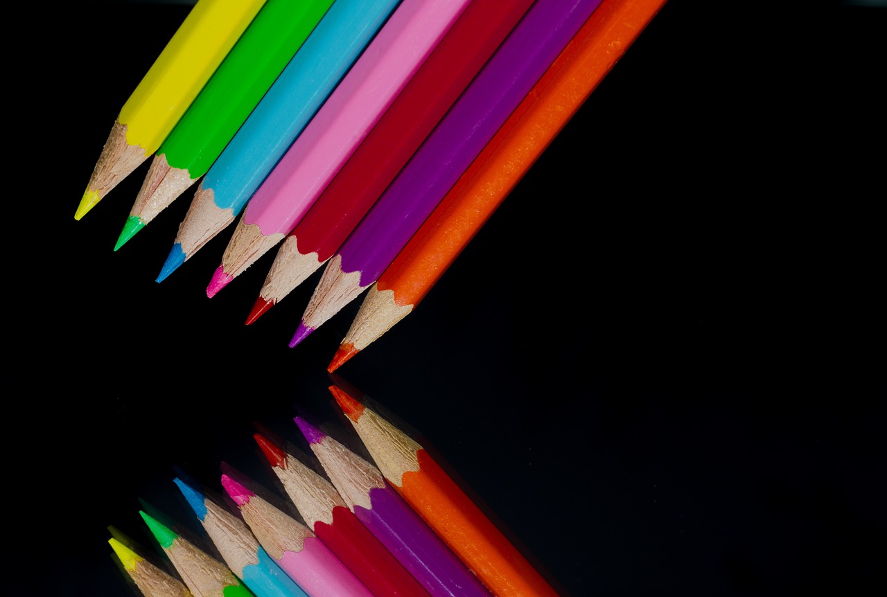 a group of colored pencils sitting next to each other, by Jan Rustem, black studio background color, perfect symmetrical image, layers of colorful reflections, very sharp photo