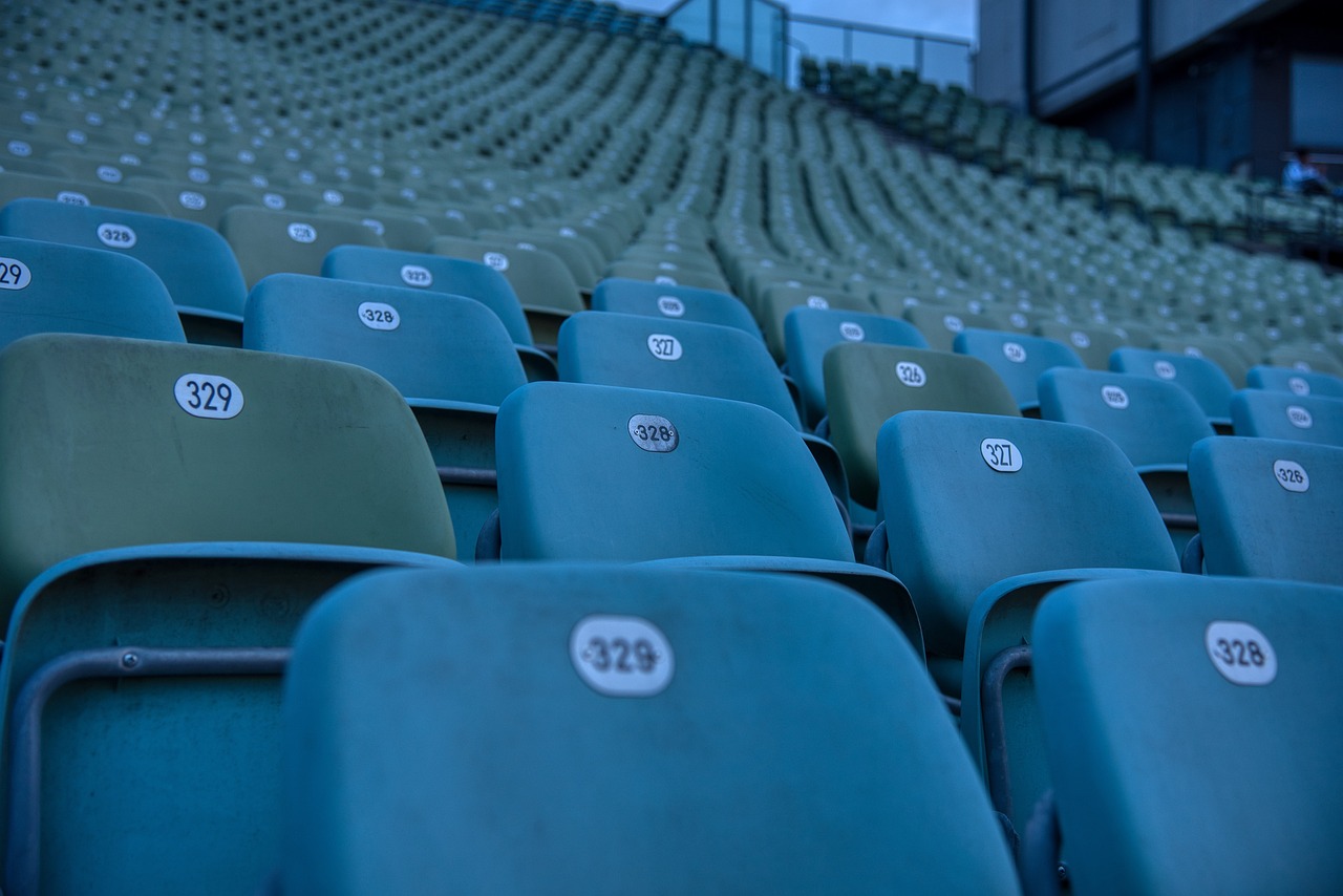 a row of green stadium seats with numbers on them, a tilt shift photo, shot on canon eos r 5, los angeles ca, lonely atmosphere, over-shoulder shot