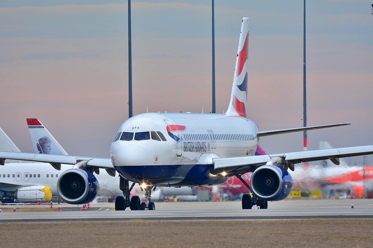 a large jetliner sitting on top of an airport runway, a picture, by Paul Bird, shutterstock, union jack, morning detail, gate, turbulence