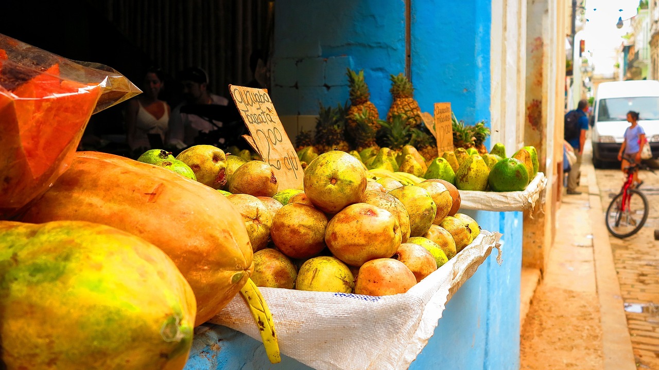 a bunch of fruit sitting on top of a table, a photo, flickr, cuba, yellow and blue, food stall, potato