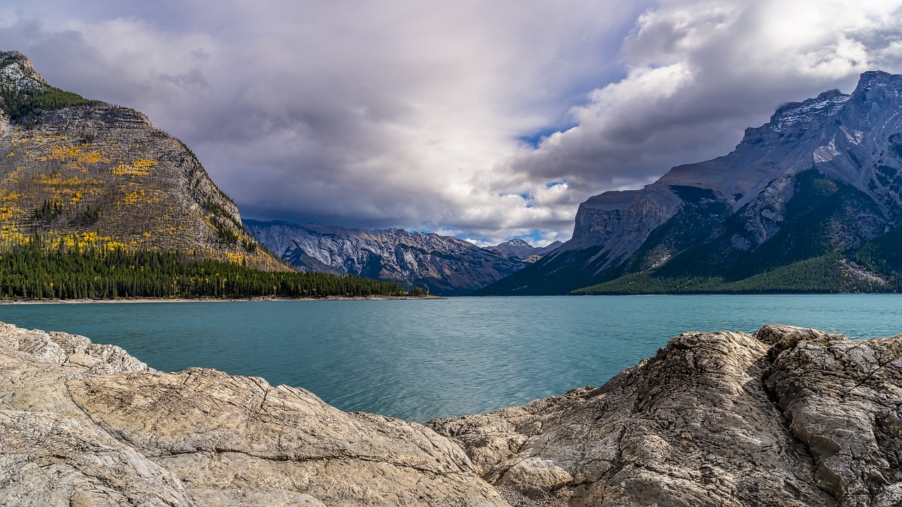 a large body of water with mountains in the background, a portrait, by Raymond Normand, shutterstock, fine art, banff national park, ultra wide 1 0 mm, brooding clouds', mid fall