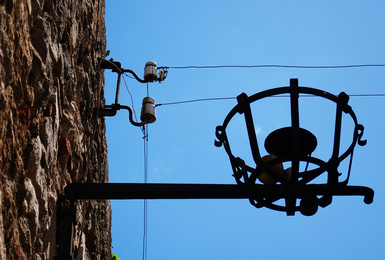 a street light hanging off the side of a building, by Alfons von Czibulka, bells, wires connected, tourist photo, blog-photo