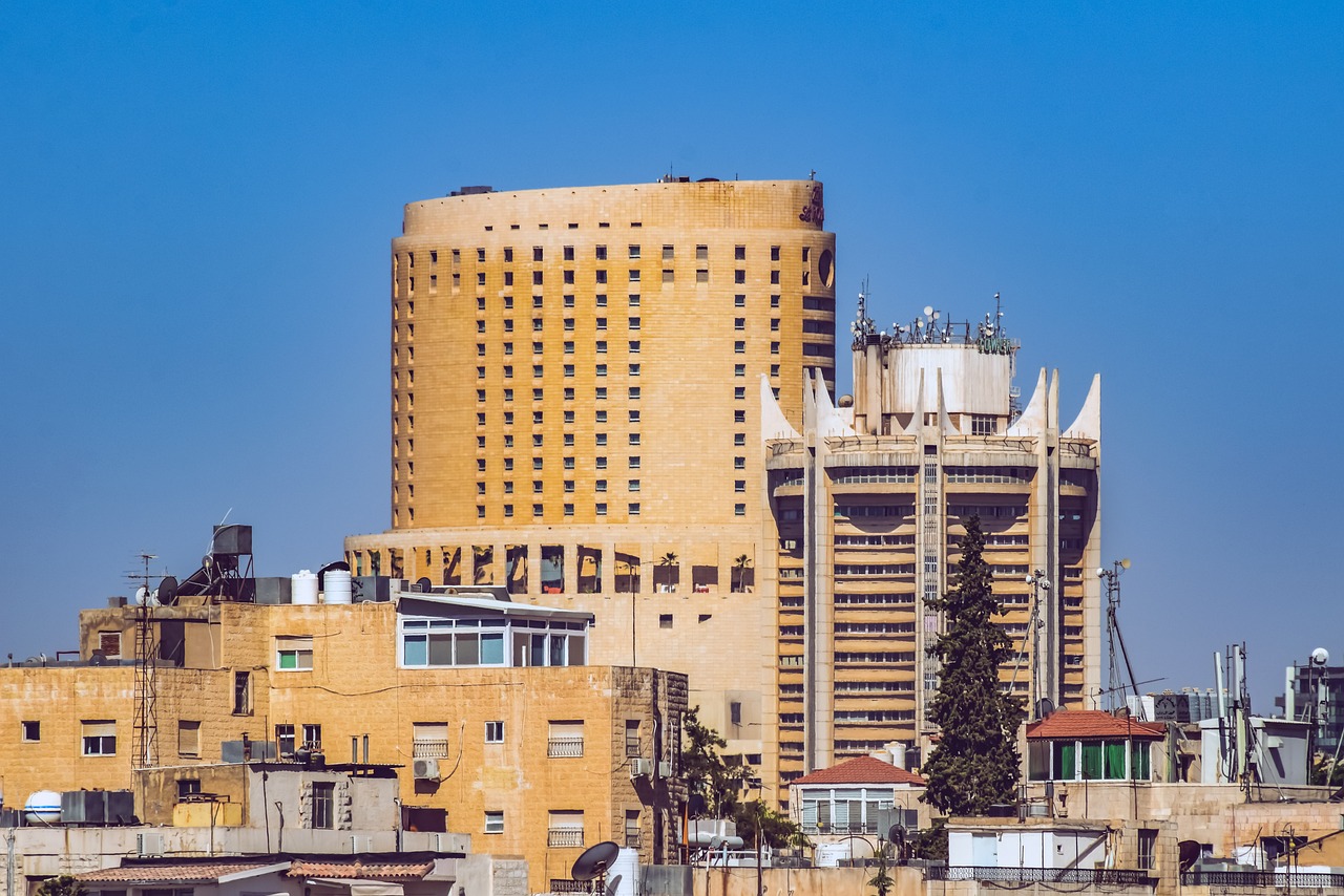 a very tall building sitting in the middle of a city, by Reuben Nakian, shutterstock, damascus, hospital, israel, seventies