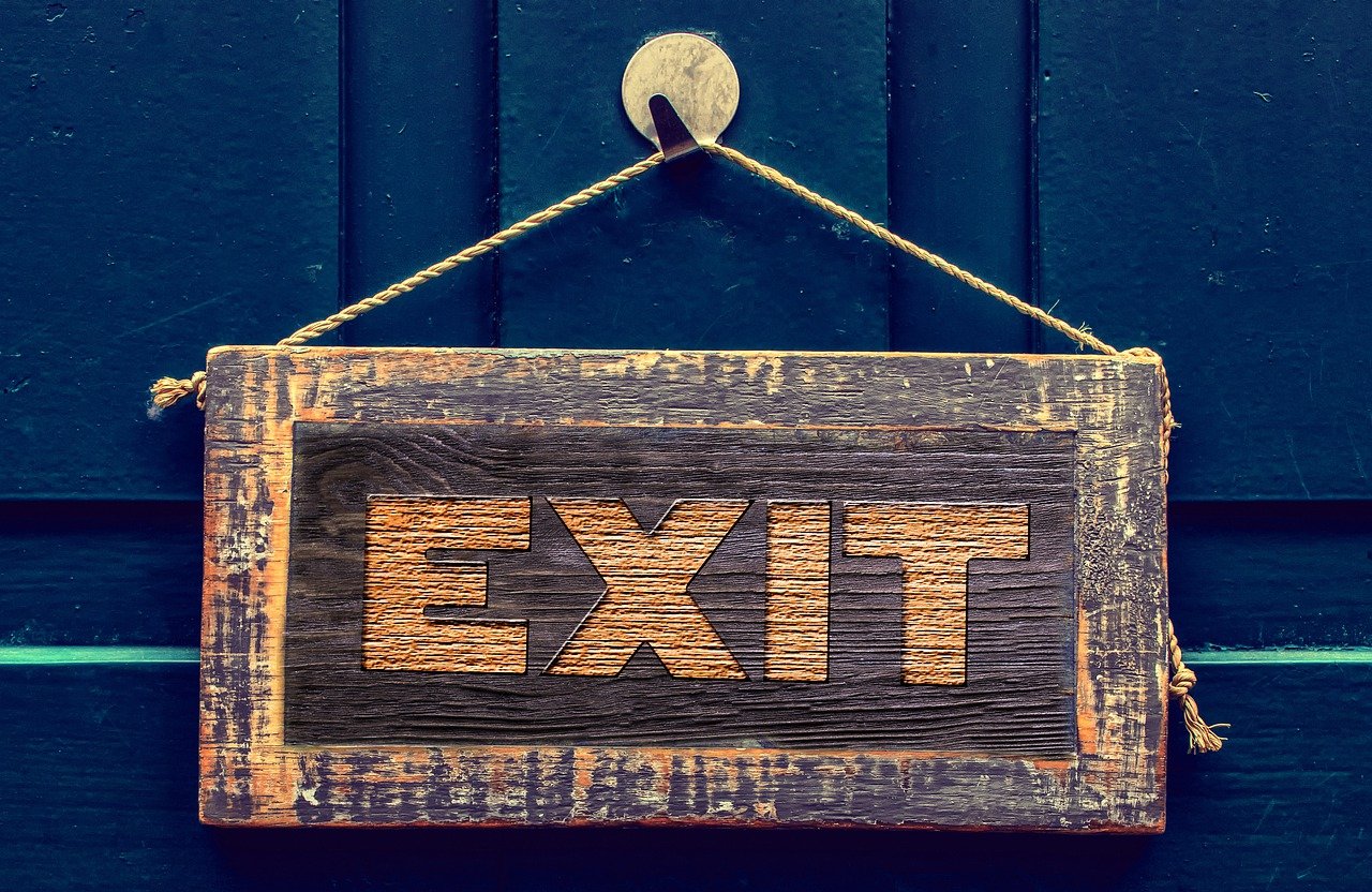 a wooden exit sign hanging on a blue door, a stock photo, excessivism, packshot, rich texture, is being drawn into a blackhole, taken in the early 2020s