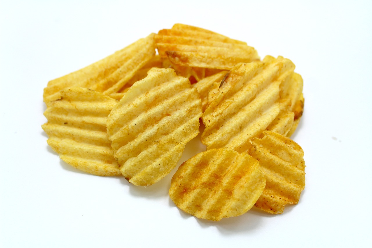 a pile of potato chips on a white surface, a stock photo, hard lines, photo taken from behind, about to consume you, product introduction photo