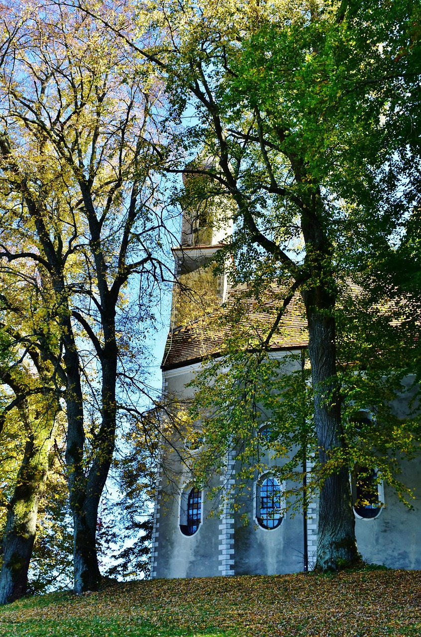 a church with a steeple surrounded by trees, a photo, by Karl Völker, featured on pixabay, romanesque, trees with lots of leaves, shot with iphone 1 0, tallinn, close-up view