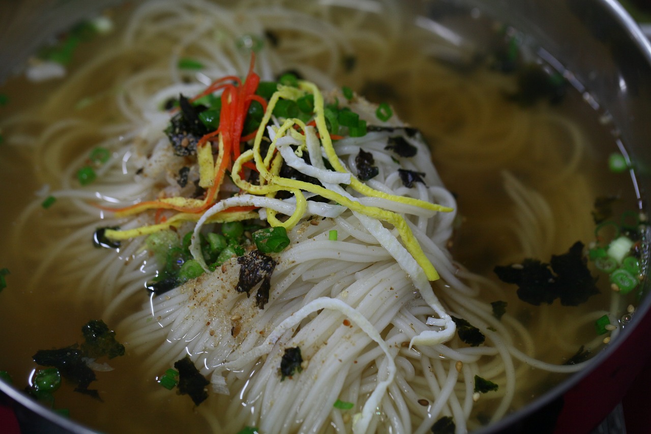 a pot filled with noodles and vegetables on top of a table, inspired by Tan Ting-pho, flickr, sōsaku hanga, depth detail, translucent gills, song nan li, closeup photo