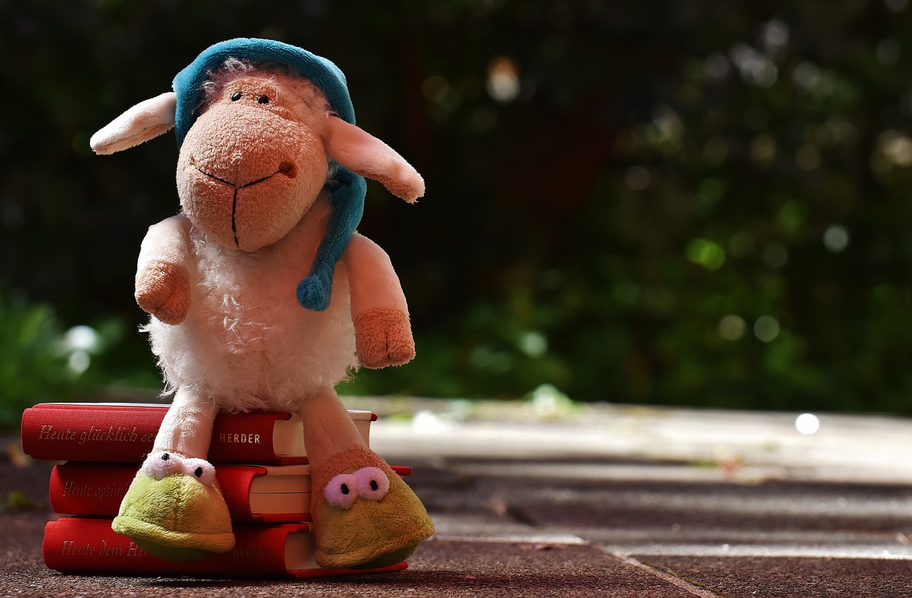 a stuffed sheep sitting on top of a stack of books, inspired by Leo Leuppi, pixabay contest winner, a robot reading a book in a park, toy photo, animal wearing a hat, storybook wide shot :: hd