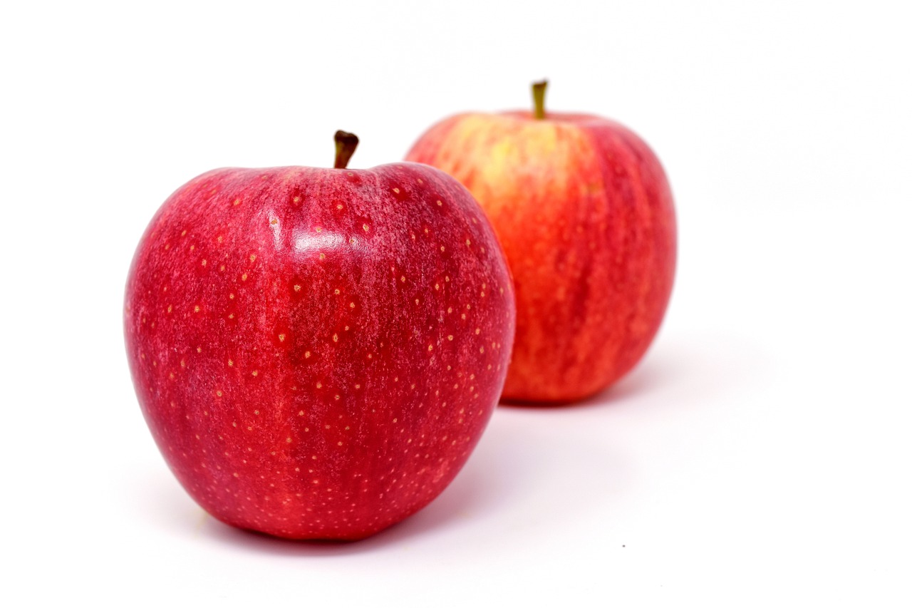 two red apples sitting side by side on a white surface, a picture, by John Luke, pexels, compressed jpeg, istockphoto, 5 feet away, dominating red color