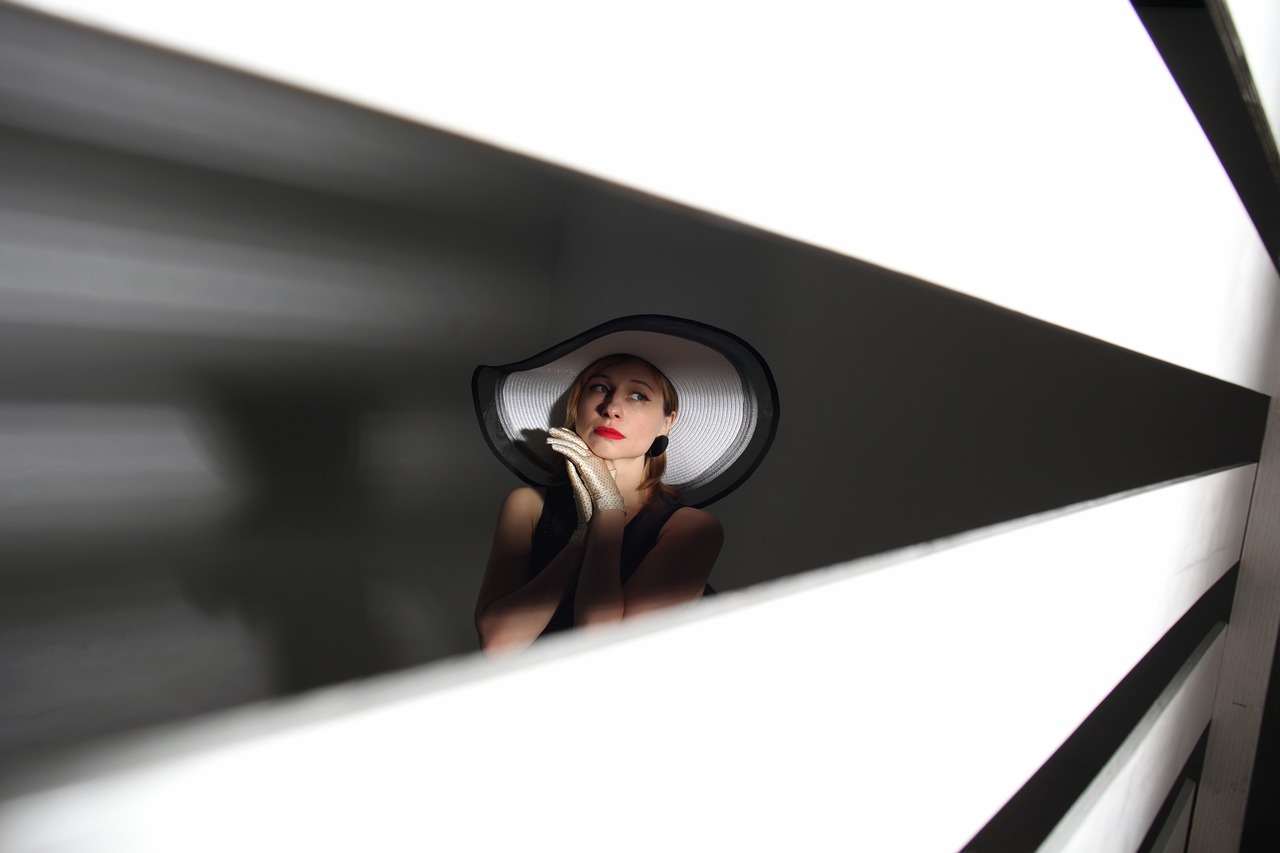 a woman taking a picture of herself in a mirror, inspired by Lillian Bassman, minimalism, white hat, low angle photo, in elegant decollete, softbox lighting