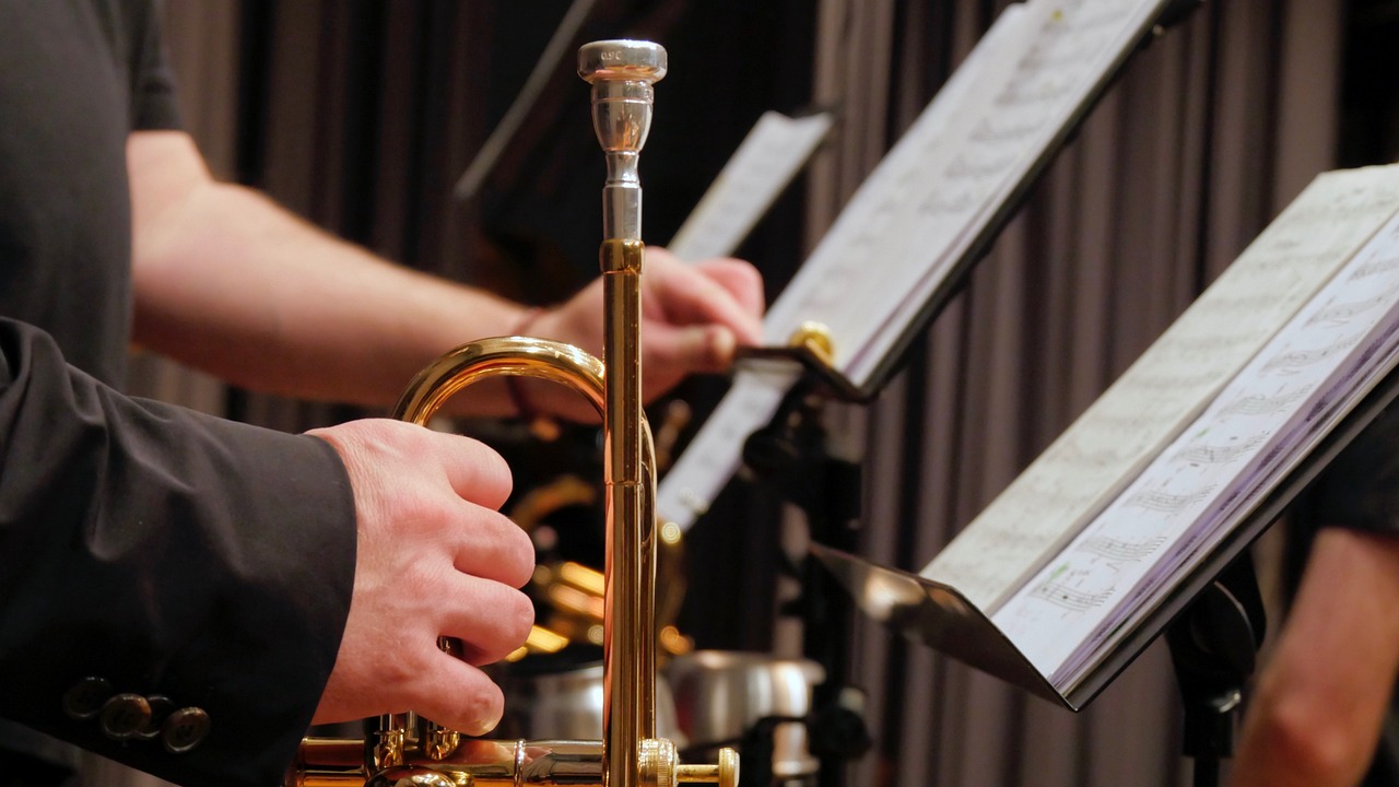 a close up of a person playing a trumpet, precisionism, brass equipment and computers, closeup of arms, sheet music, band playing