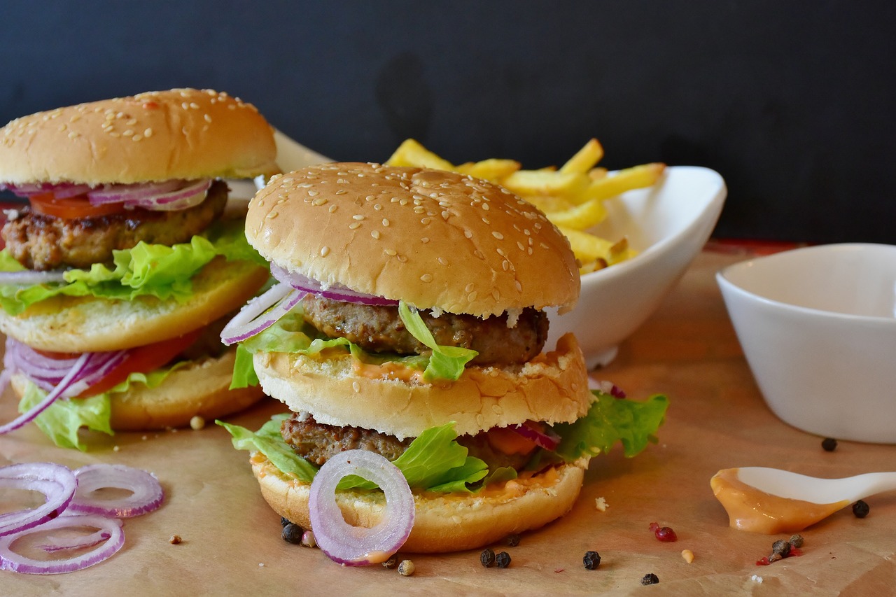 a couple of hamburgers sitting on top of a wooden cutting board, a picture, by Tom Wänerstrand, pexels, avatar image, serving big macs, wallpaper - 1 0 2 4, small