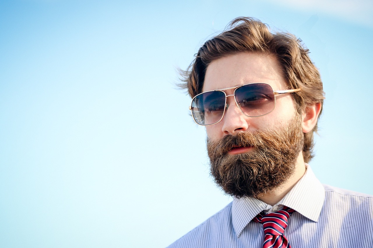 a man with a beard wearing sunglasses and a tie, by Andrei Kolkoutine, shutterstock, beautiful hairy humanoids, florida man, preppy style, 3 2 - year - old