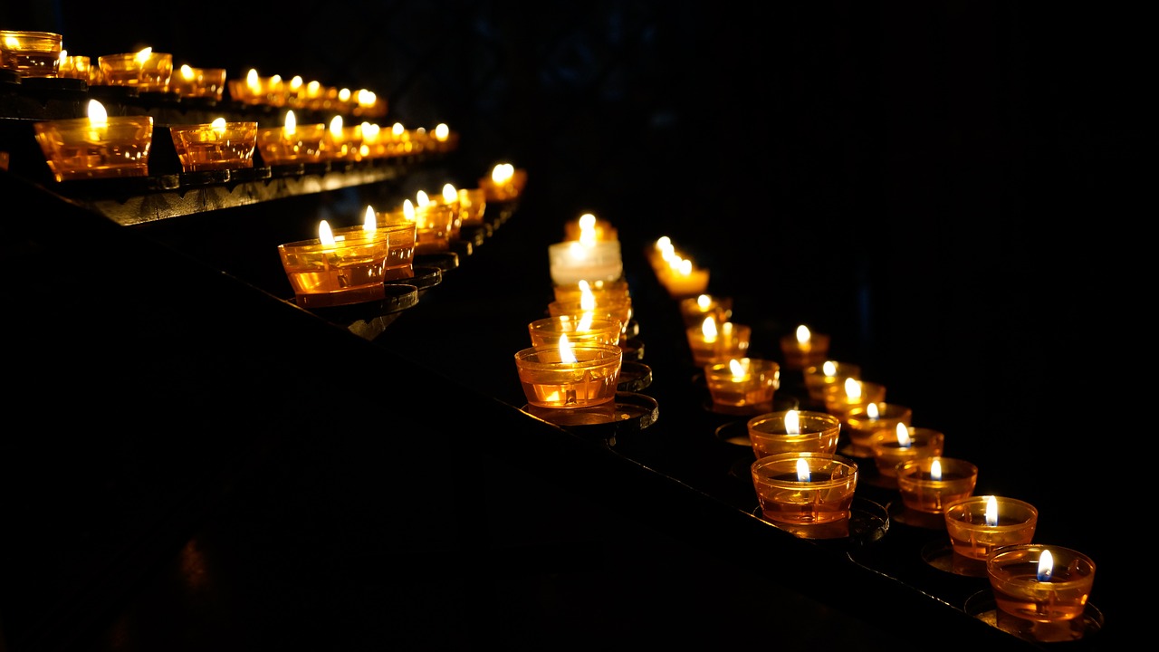 a row of lit candles sitting on top of a table, a photo, holy lights, night photo, ossuary, warm volumetric lights
