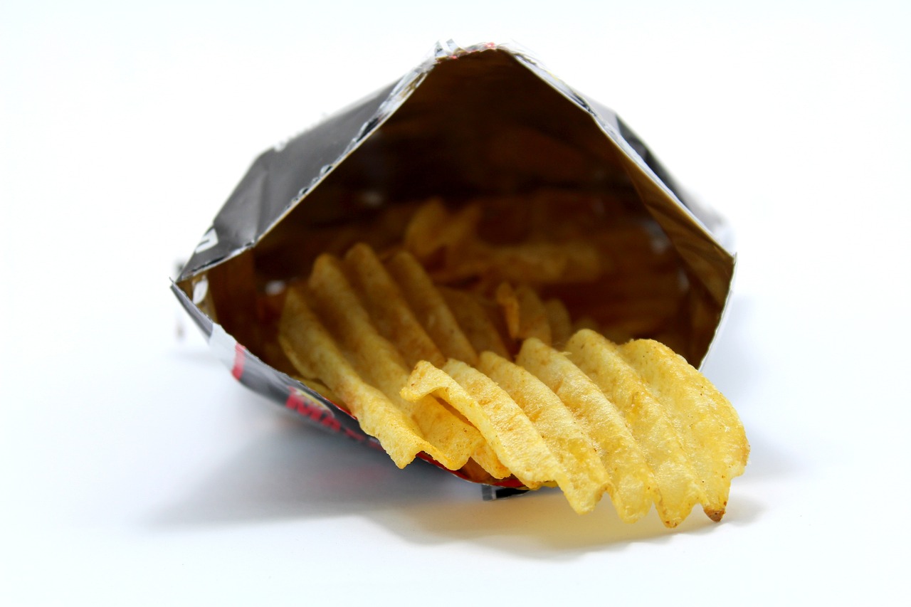 a bag of french fries sitting on top of a table, a picture, photorealism, close-up shot from behind, silver, crisps, flash photo