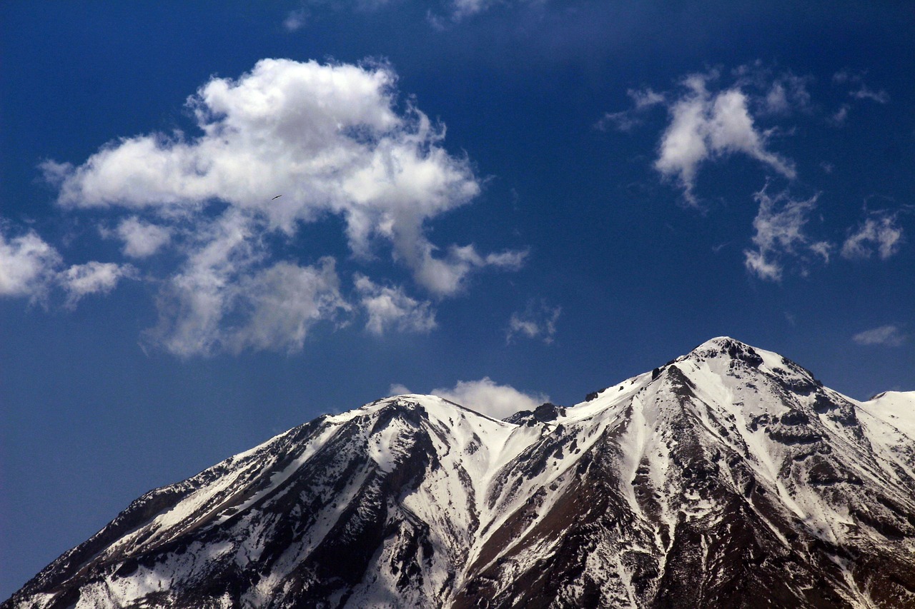 a plane flying over a snow covered mountain range, by Sohrab Sepehri, flickr, tehran, ceremonial clouds, highly_detailded, beautiful day