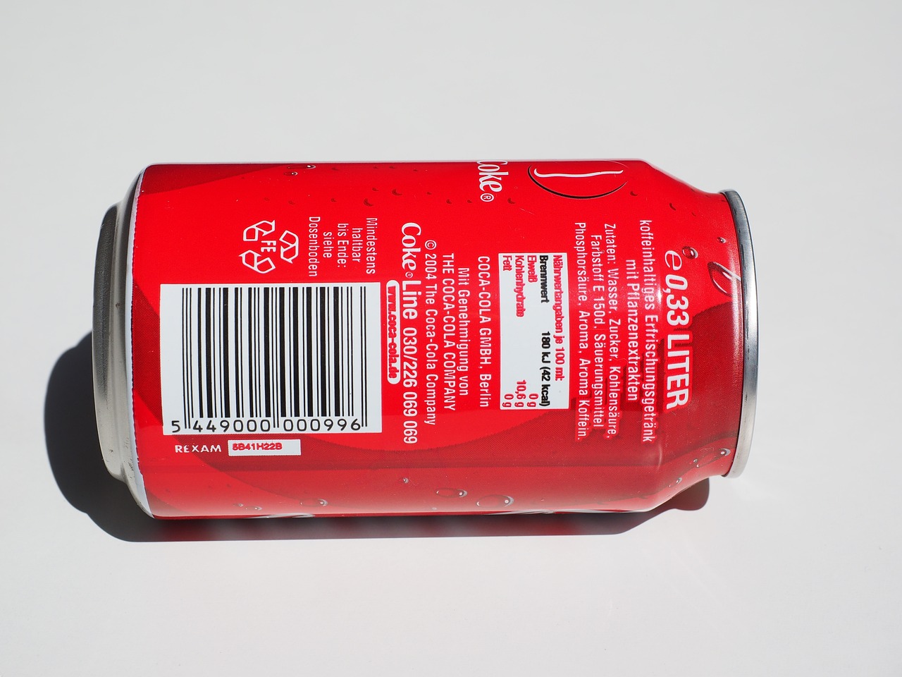 a can of soda sitting on top of a table, a picture, backview, metallic red, barcode, product photograph
