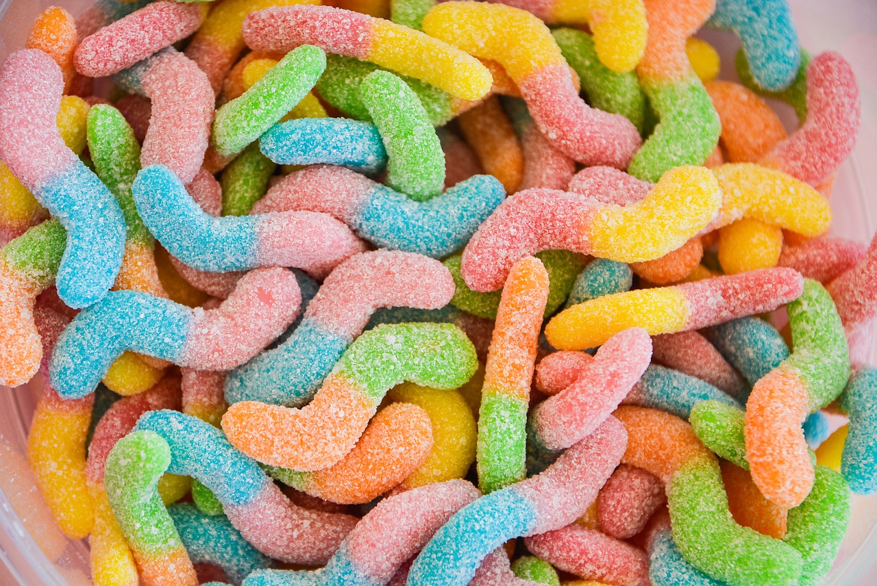 a bowl filled with gummy worms sitting on top of a table, a microscopic photo, shutterstock, full of colour 8-w 1024, pastel glaze, mid closeup, seventies