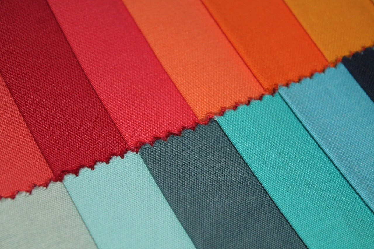 a close up of a variety of different colored fabrics, inspired by Toss Woollaston, color field, vermillion and cyan, tonal colors outdoor, color blocking!, detailed cloth
