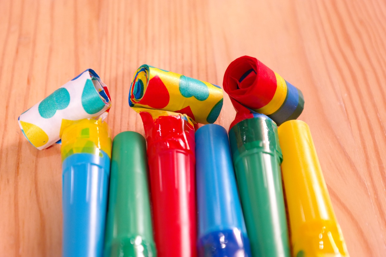 a group of colorful pens sitting on top of a wooden table, inspired by Hans Hofmann, shutterstock, toothpaste blast, at a birthday party, broken pipes, 35 mm product photo”