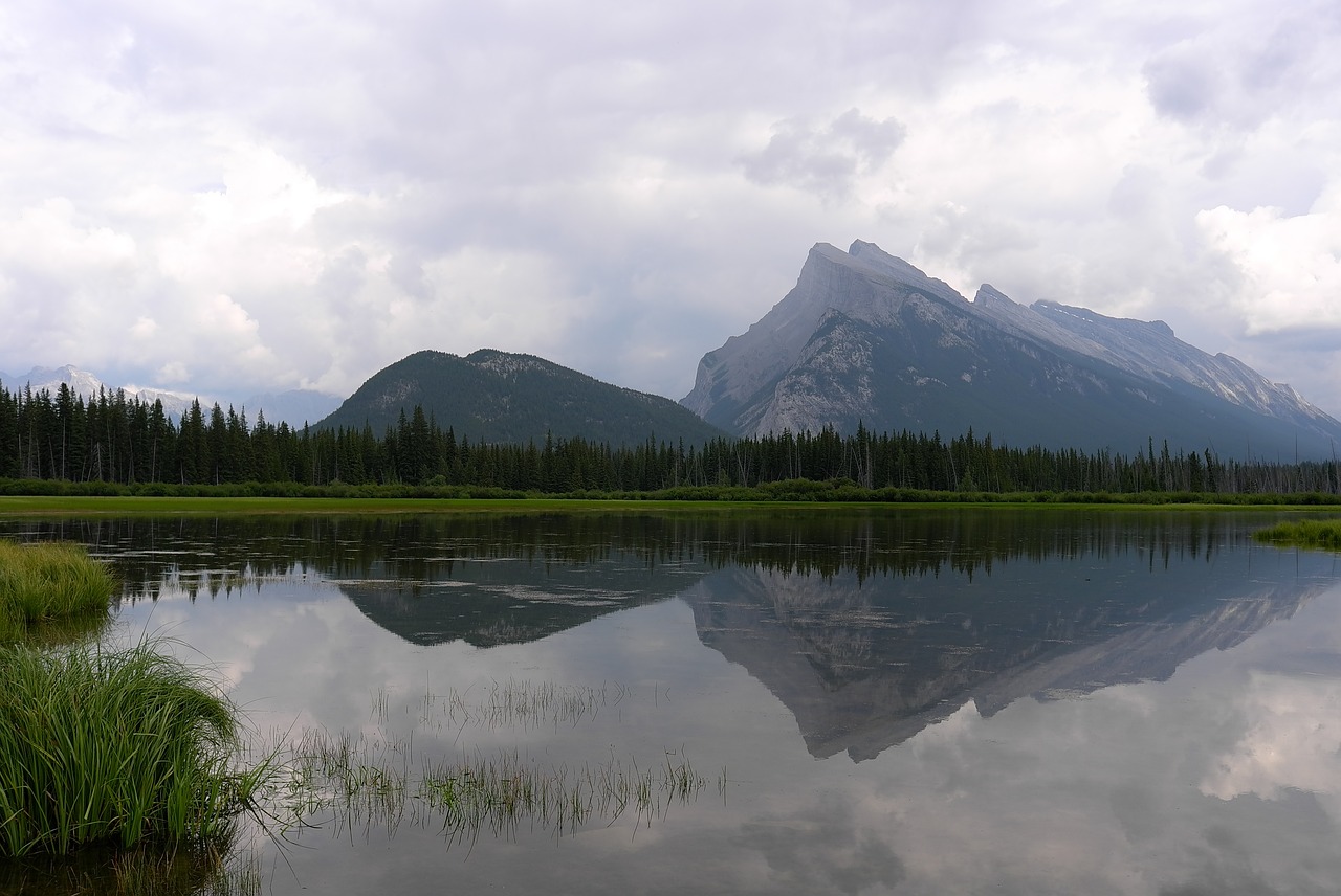 a body of water with a mountain in the background, a picture, inspired by Robert Bateman, pixabay, banff national park, reflection puddles, july 2 0 1 1, very very wide shot