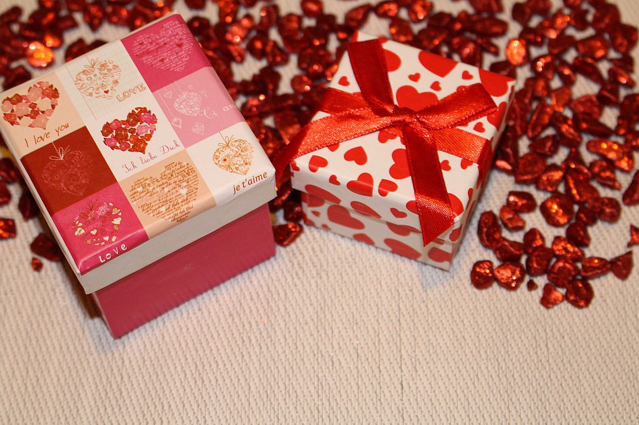 a couple of boxes sitting on top of a table, by Maksimilijan Vanka, pixabay, red hearts, pink and red color scheme, presents, olivia kemp