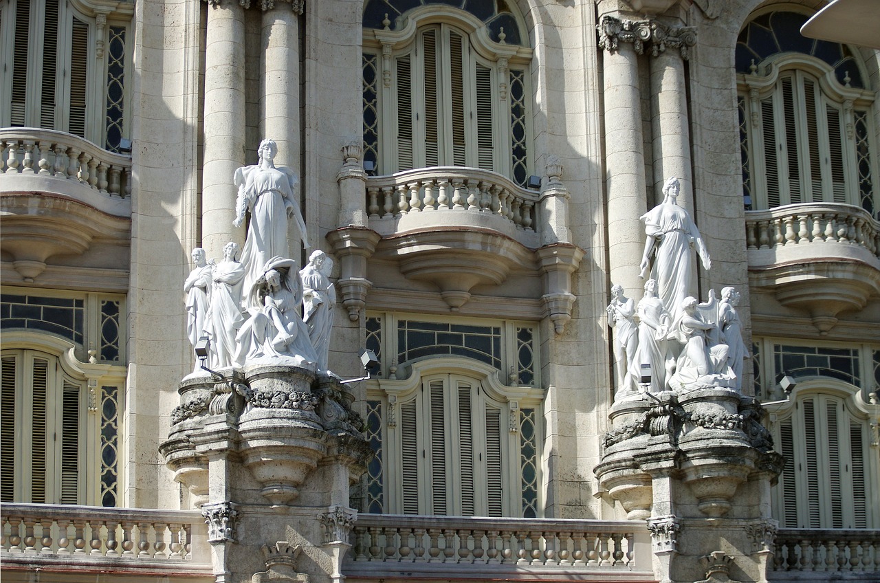 a couple of statues that are on the side of a building, by Luis Paret y Alcazar, flickr, baroque, cuban setting, balcony scene, spires, lots of glass details