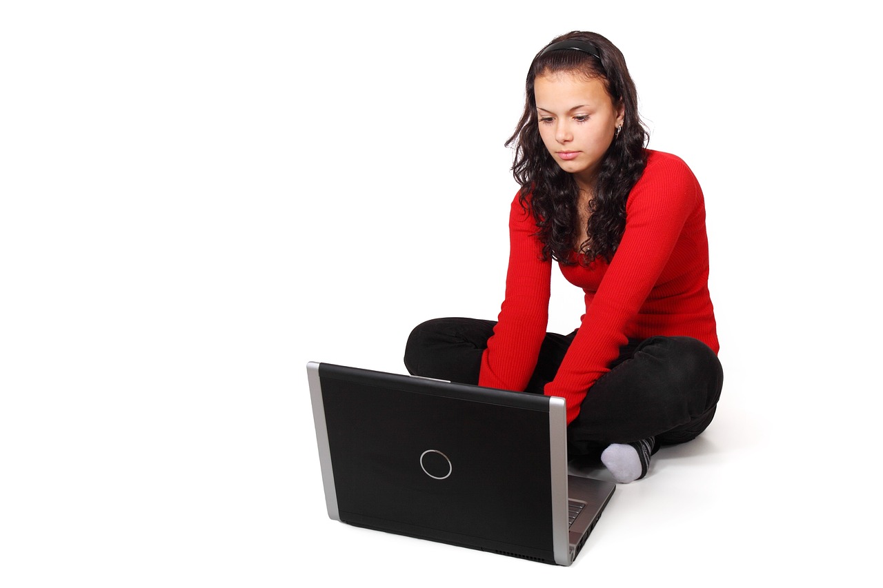 a woman sitting on the floor with a laptop, a photo, red shirt, istockphoto, full length photo, dlsr photo
