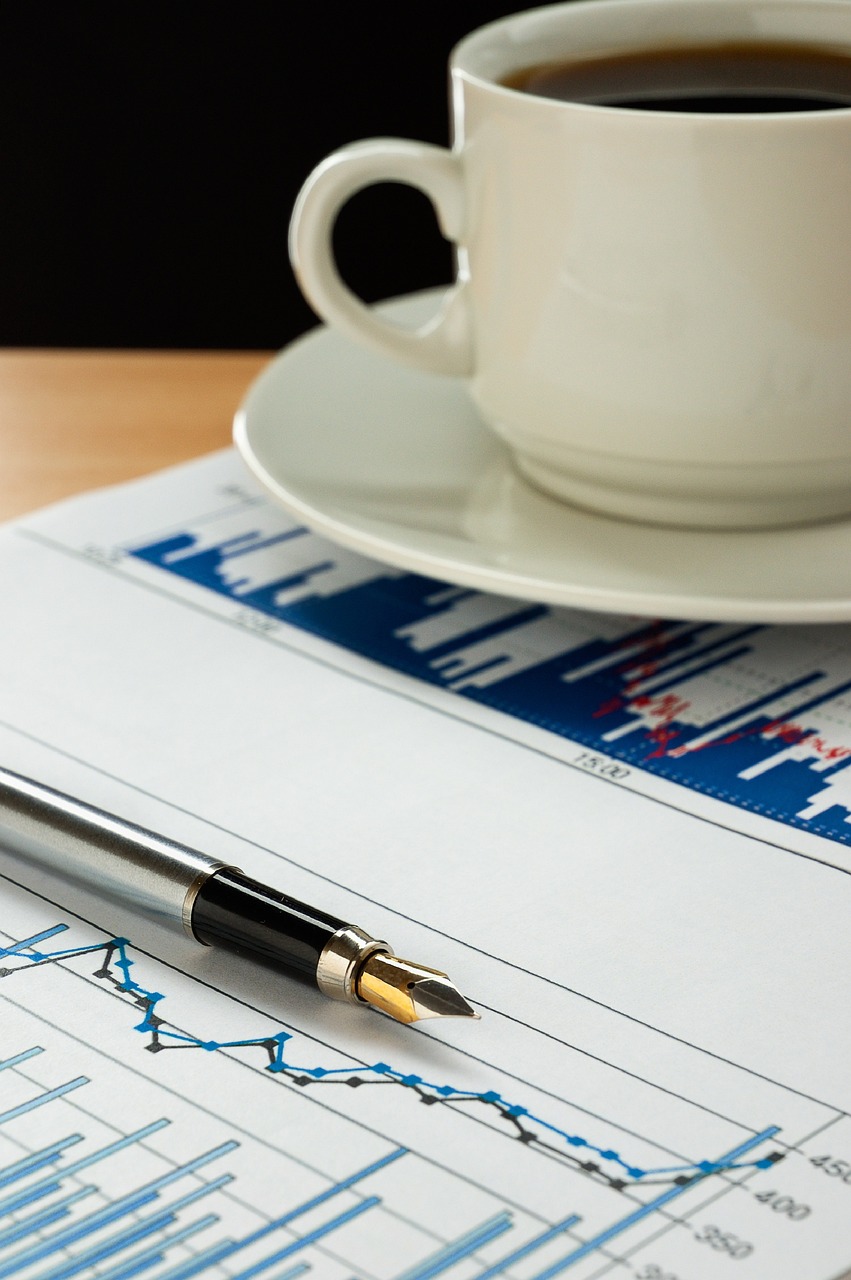 a pen sitting on top of a piece of paper next to a cup of coffee, shutterstock, analytical art, displaying stock charts, closeup photo, set photo, detailed picture