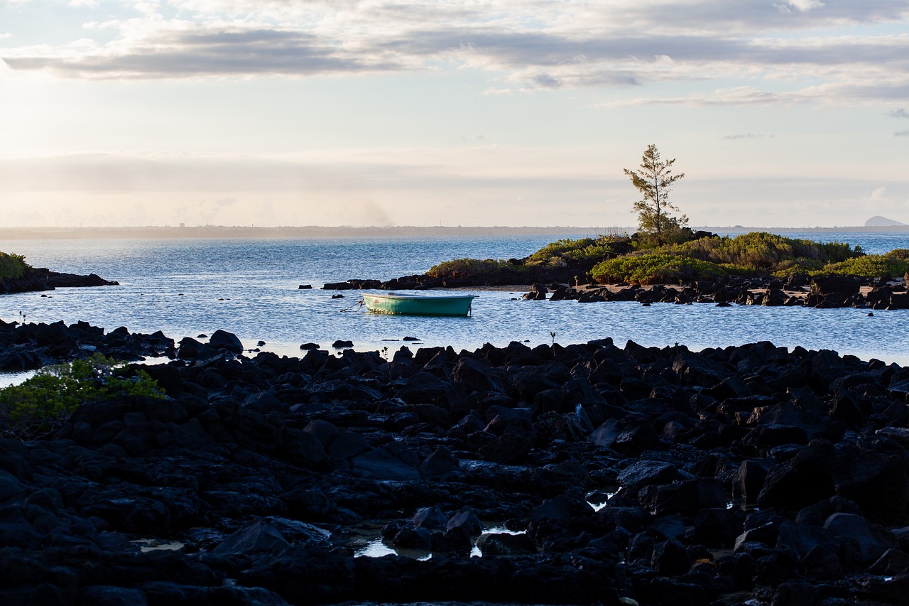 a boat floating on top of a body of water, by John Souch, flickr, lava rock, late summer evening, cape, portlet photo