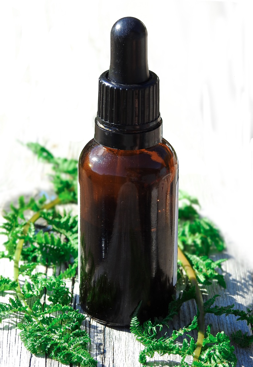 a brown bottle sitting on top of a wooden table, by Jan Rustem, pixabay, hurufiyya, moss and ferns, clean face and body skin, black oil, asymmetrical