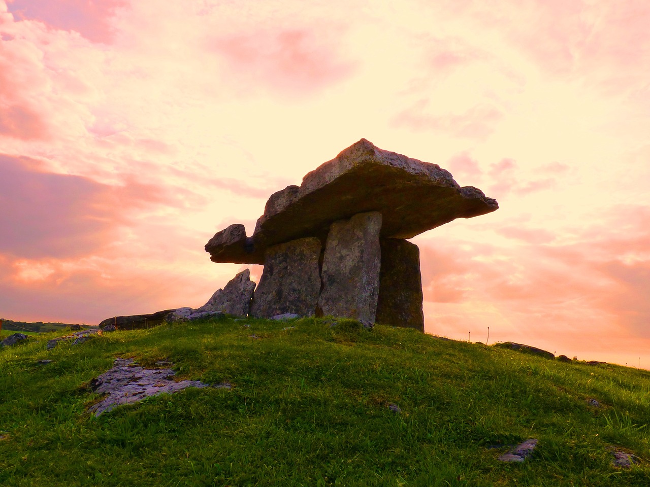a large rock sitting on top of a lush green hillside, a picture, romanticism, ancient irish, stone table, godrays at sunset, portal