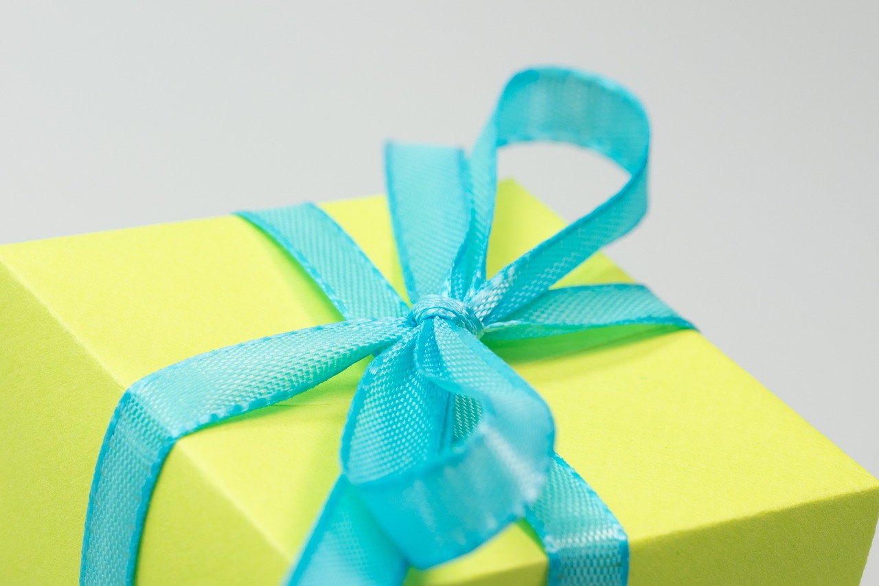 a yellow gift box with a blue ribbon, a macro photograph, pexels, minimalism, cyan and green, close-up product photo, istockphoto, 4 k product photo