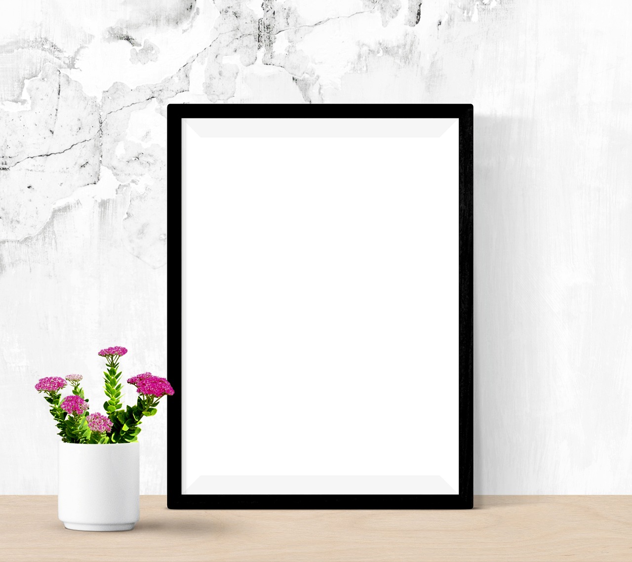 a picture frame sitting on top of a wooden table, a poster, minimalism, flowers in background, large vertical blank spaces, white marble, black border