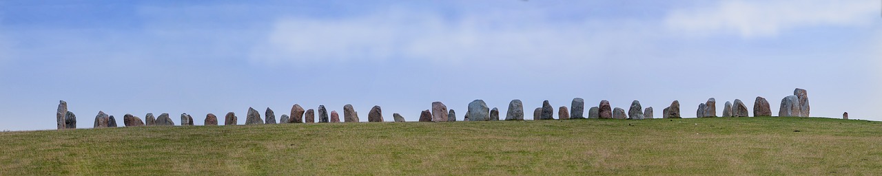 a herd of sheep standing on top of a lush green hillside, by Jan Rustem, land art, menhirs, colour corrected, stone runes on the front, panorama