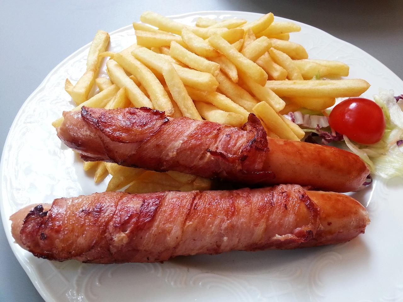 a white plate topped with two hot dogs and french fries, a picture, by Tom Wänerstrand, pixabay, bacon, old english, shiny crisp finish, belgium