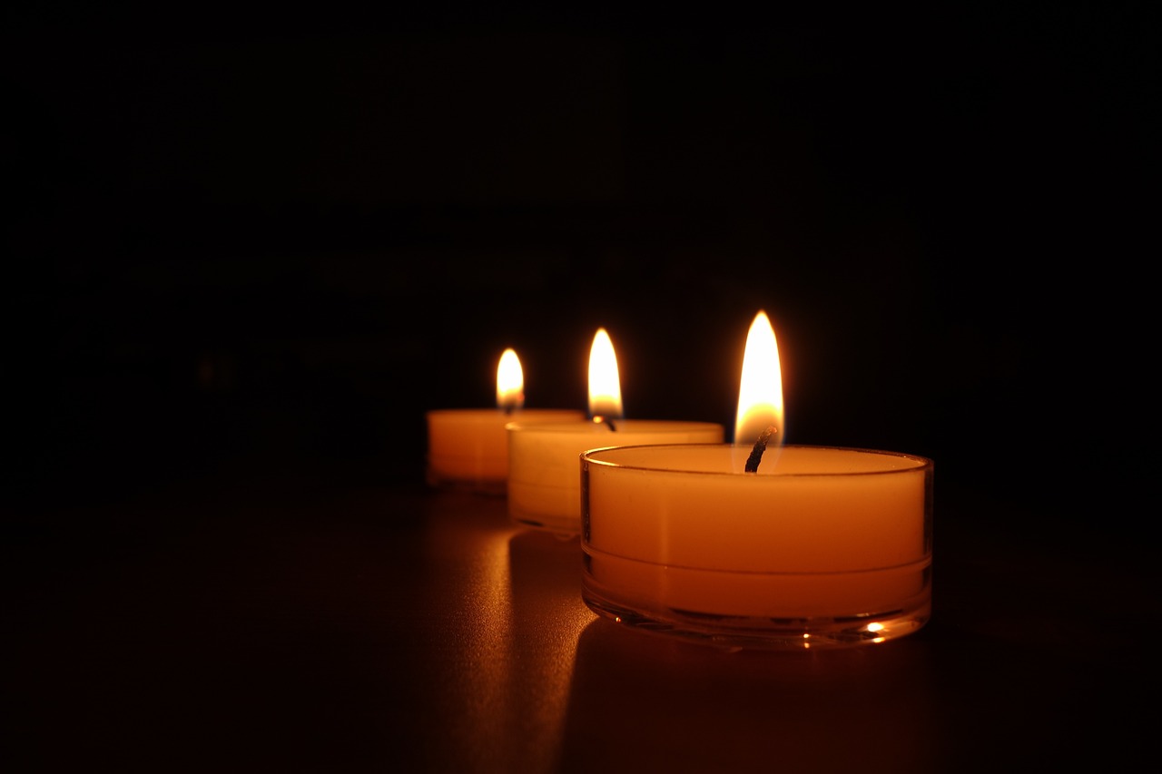 three lit candles sitting on a table in the dark, a picture, night photo, where being rest in peace, in a row, noon