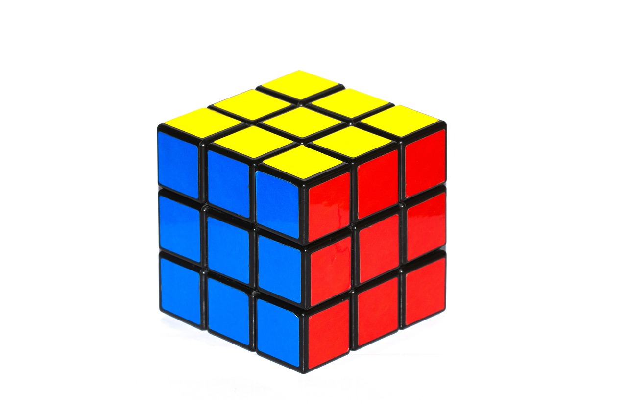a rubik cube sitting on top of a white surface, a jigsaw puzzle, cubo-futurism, black and yellow and red scheme, high quality product image”, istockphoto, 30 years old