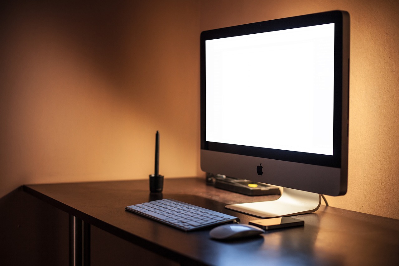a computer monitor sitting on top of a wooden desk, by Jason Felix, pexels, warm lighting interior, blank background, apple design, high res photo