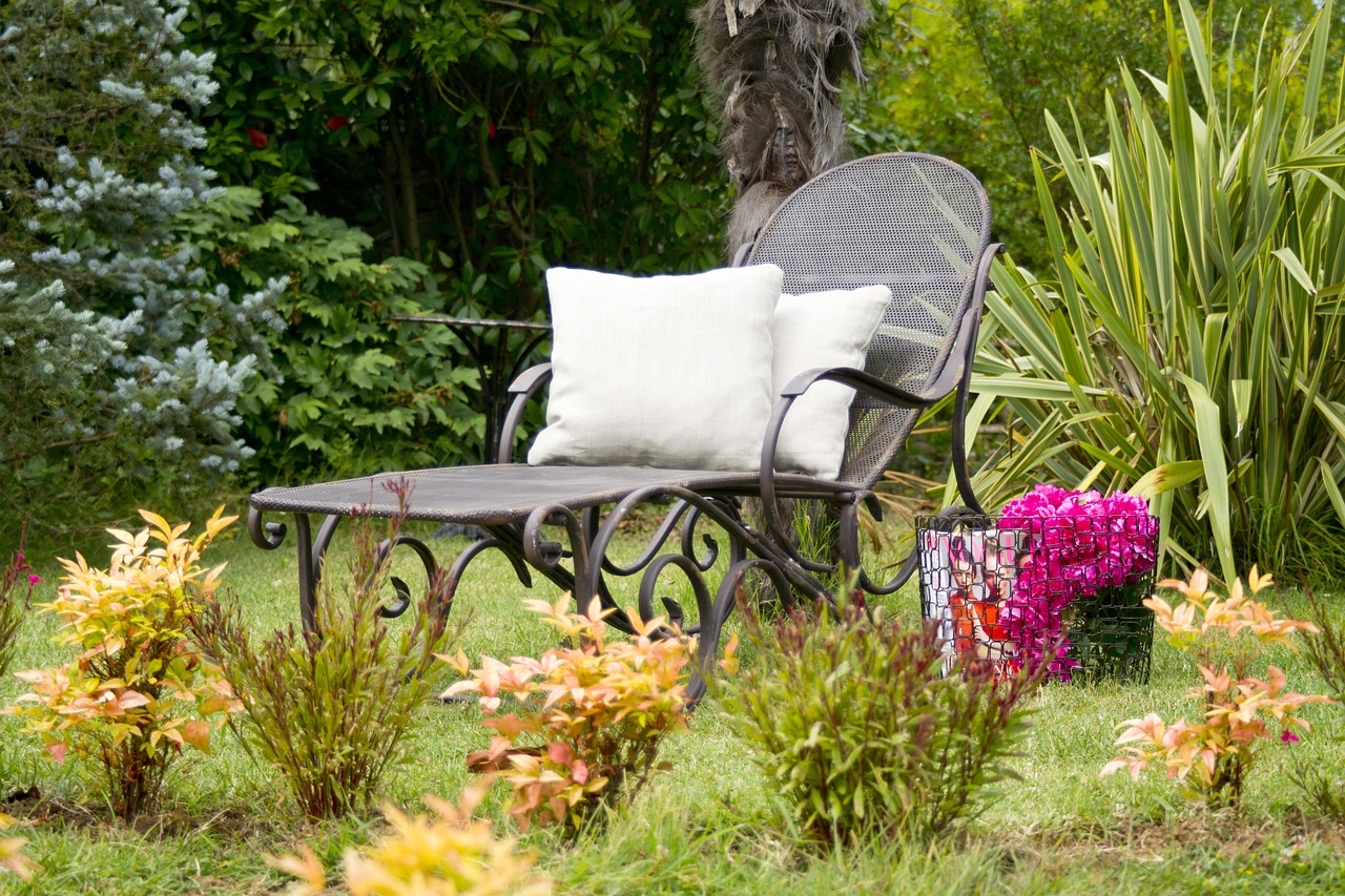 a chair sitting on top of a lush green field, by Joy Garnett, figuration libre, plants and patio, wrought iron, commercial product photography, in a sun lounger