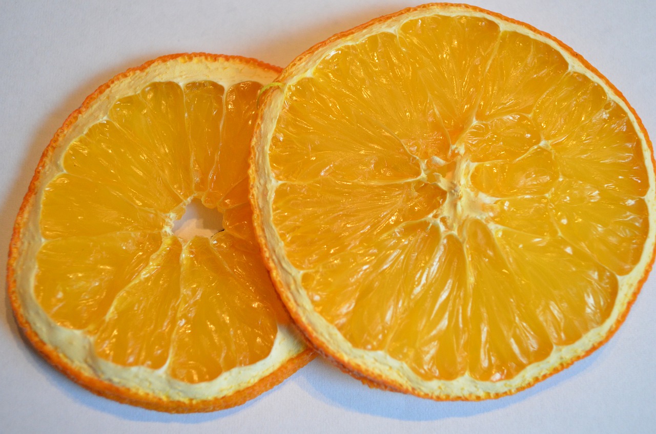 two halves of an orange on a white surface, by David Garner, process art, hyperdetailed!, taken with a pentax1000, optimus sun orientation, alex from a clockwork orange