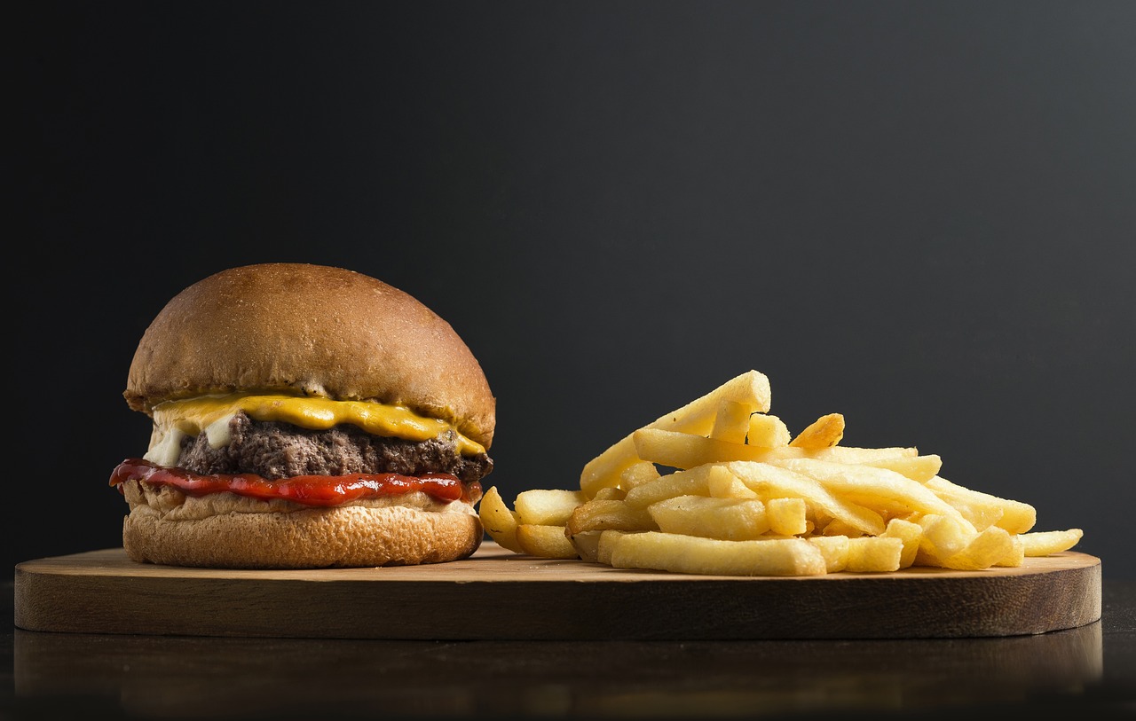 a hamburger and french fries on a cutting board, a picture, by Jesper Knudsen, on a dark background, 🔥 😎 🕹️ 👀, istock, stock photo