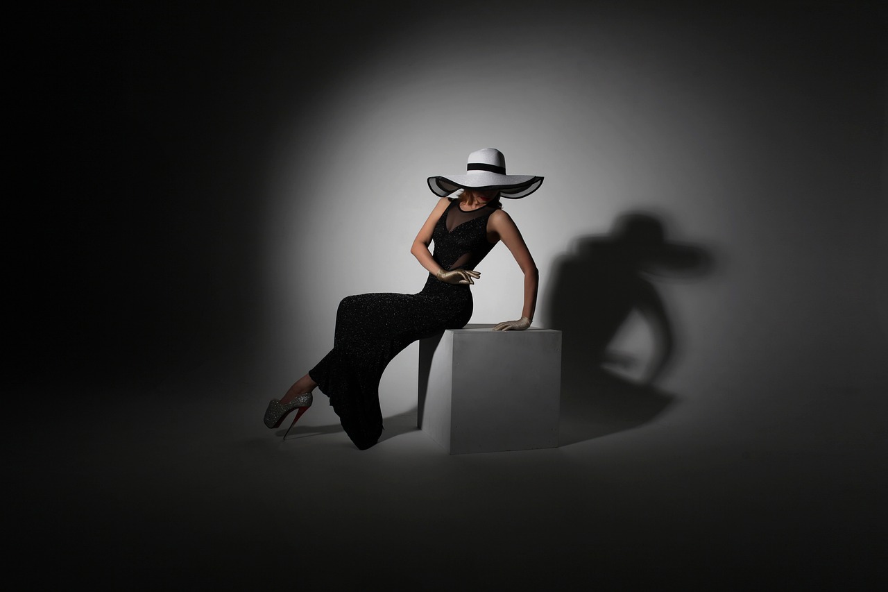 a woman sitting on top of a cube wearing a hat, a portrait, inspired by Horst Antes, trending on cg society, dramatic lowkey studio lighting, wearing wide sunhat, full - length photo, white on black