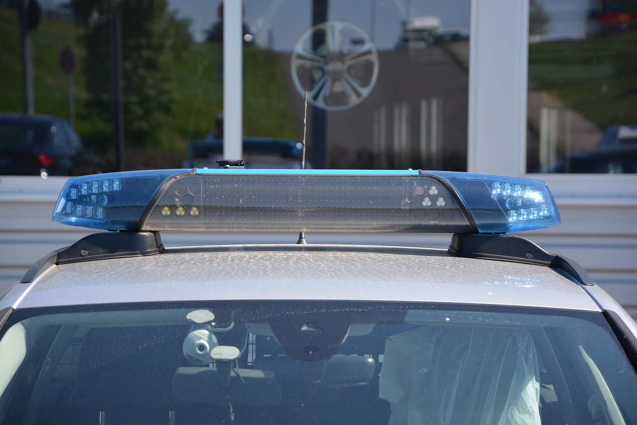 a police car parked in front of a building, a hologram, by Karl Völker, glass oled visor head, overhead canopy, guardrail, natural light