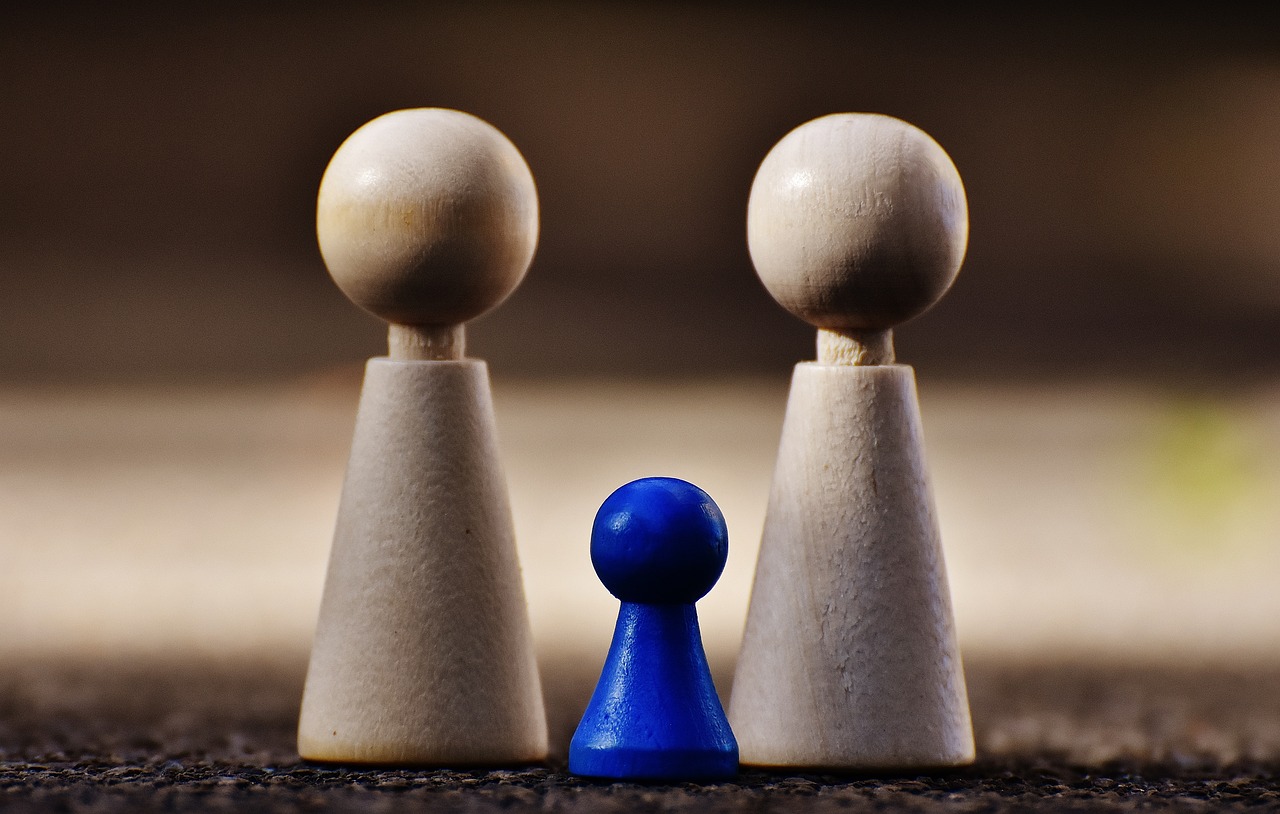 a couple of wooden pawns sitting next to each other, a picture, by Jesper Knudsen, ultramarine, the man stands out on the image, husband wife and son, cone